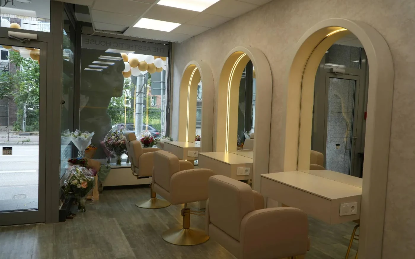Styling-Plätze mit beleuchteten Bogen-Spiegeln und goldenen Stühlen