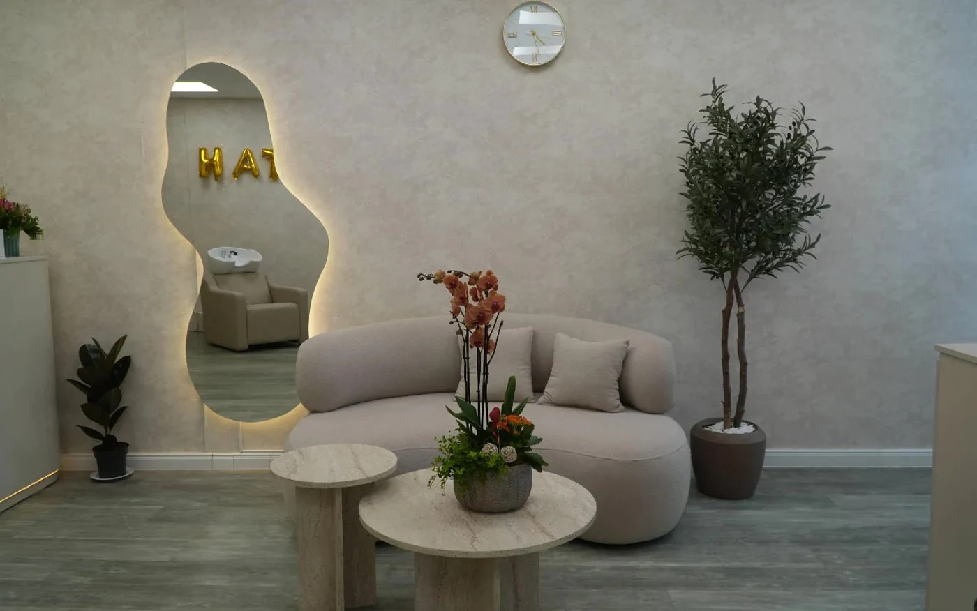Der Wartebereich mit Sofa, Spiegel und Orchideen
