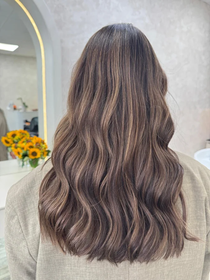 Balayage in Karamell auf dunkelbraunem Haar, weicher Verlauf zu den Spitzen