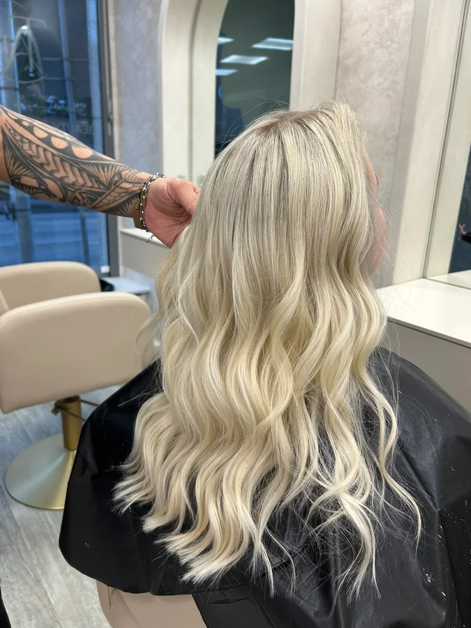 Kühles Platinblond mit Strähnen, in weichen Wellen gestylt